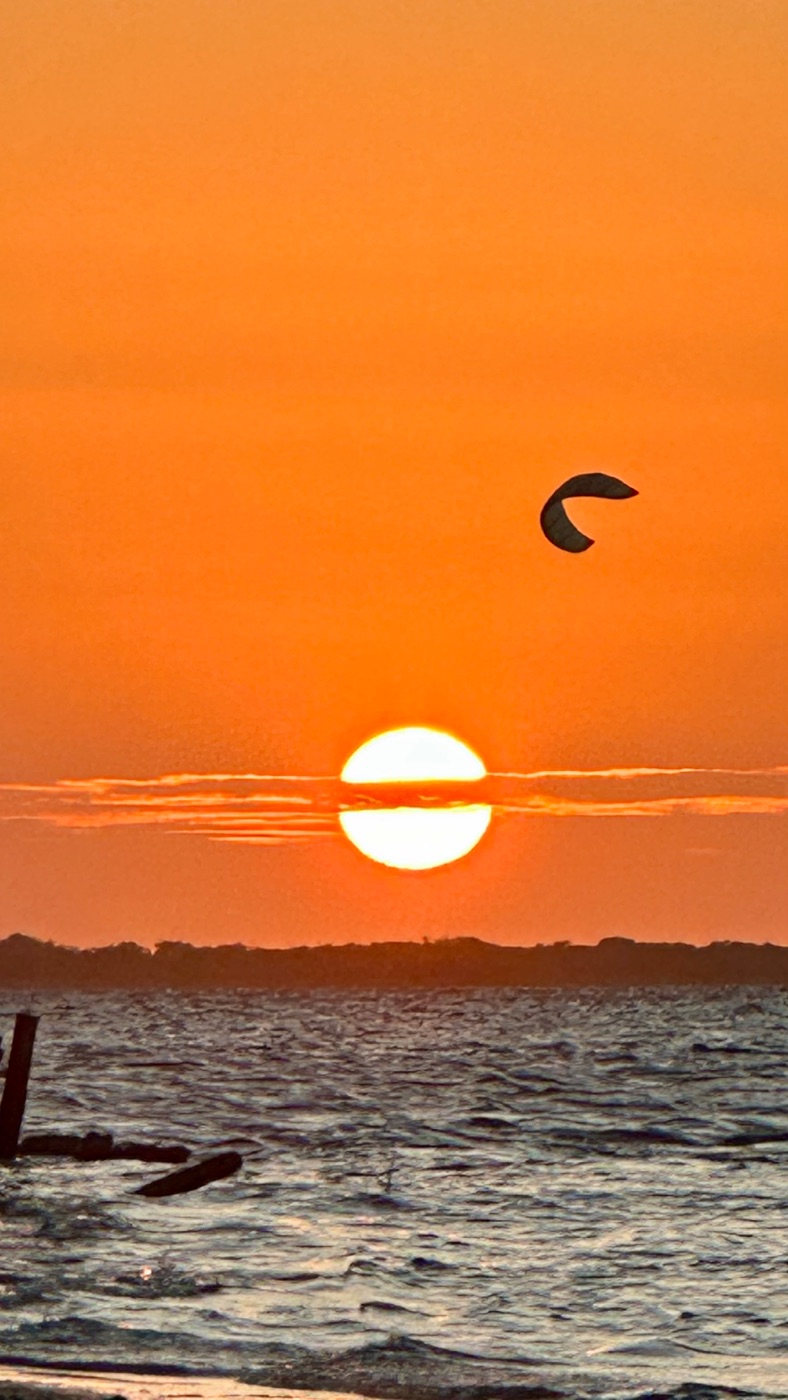 Pôr do sol com pipa de kite no céu de Atins
